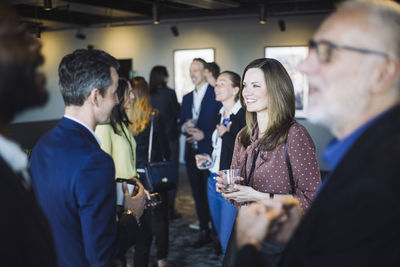 Male and female colleague discussing while standing at workplace