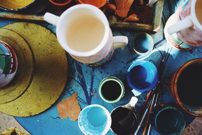 High angle view of paintbrushes and cups on table