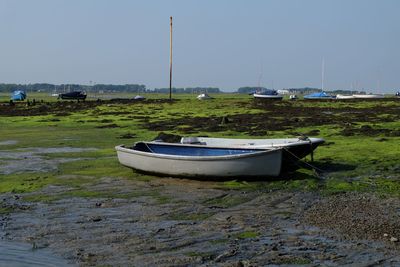 Boat moored on beach against sky