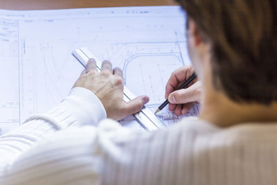 Architect working on blueprint at office