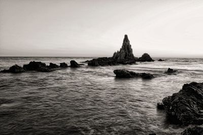 Scenic view of rocks in sea against sky