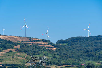 Low angle view of windmill against clear blue sky