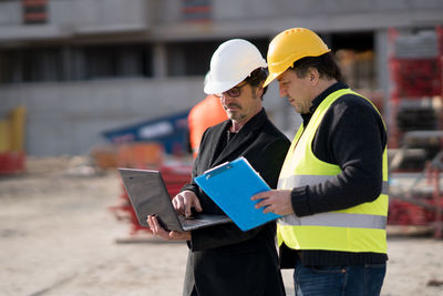 Architects using laptop at construction site