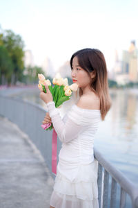 Portrait of young woman holding bouquet