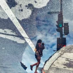 High angle view of woman with umbrella standing on puddle