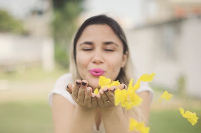 Woman blowing flowers at park