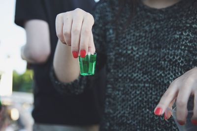 Close-up of woman holding tequila shot