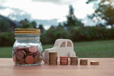 Close-up of coins on table against trees