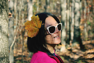 Close-up of woman wearing sunglasses standing in forest