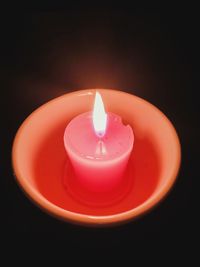 High angle view of lit candle against black background