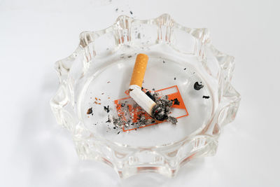 High angle view of cigarette smoking over white background