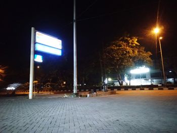 Illuminated street light on sidewalk at night