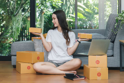 Full length of woman sitting on chair at table