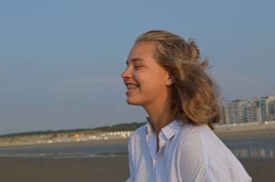 Portrait of a smiling young woman against sky