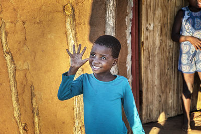 Portrait of smiling girl standing against wall