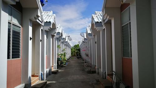 Footpath amidst buildings against sky