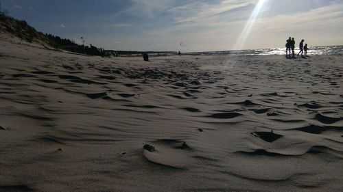 Footprints on beach against sky during sunset