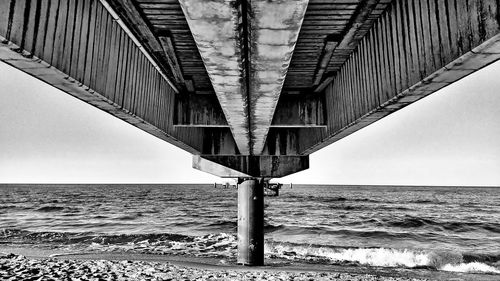 Low angle view of bridge over sea against clear sky