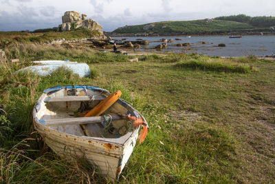 Boat on shore at beach against sky