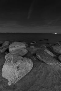 Scenic view of rocks on beach against sky