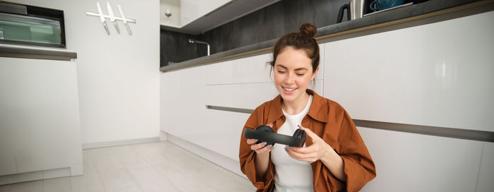 Side view of young man using mobile phone while standing at home