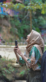 Midsection of woman using mobile phone