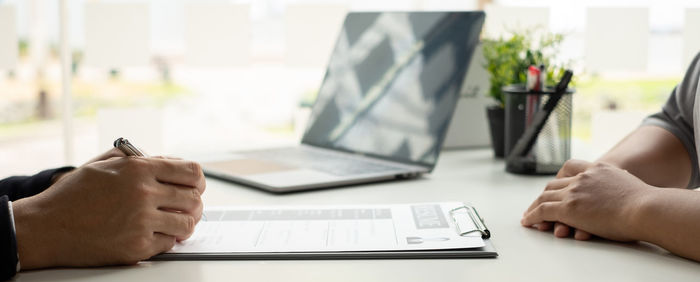 Midsection of man using laptop on table