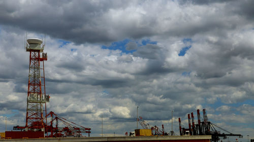 Cranes on pier against sky