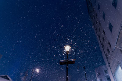 Low angle view of illuminated street light against sky at night