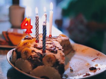 Close-up of birthday cake with candles in plate on table