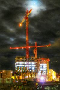 View of illuminated cityscape against cloudy sky