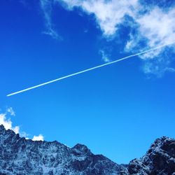 Low angle view of vapor trail against blue sky