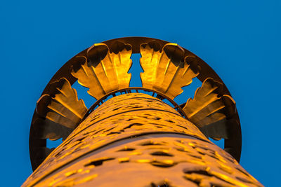 Low angle view of yellow tower against clear blue sky