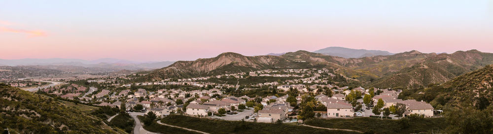 Panoramic shot of townscape by mountains against sky