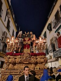 People in illuminated traditional building at night