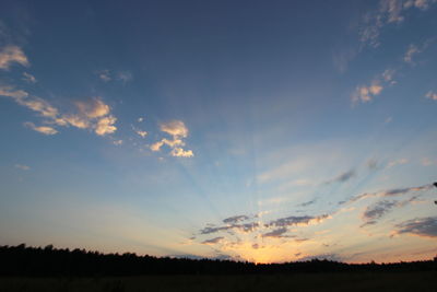 Scenic view of silhouette field against sky at sunset