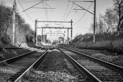 Railroad tracks on field against  sky