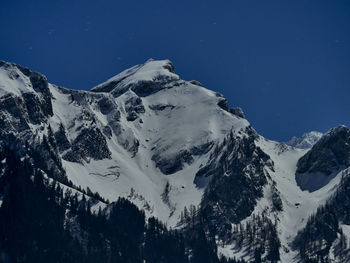 Scenic view of snowcapped mountains against blue sky