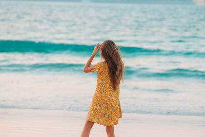 Woman with umbrella standing on beach