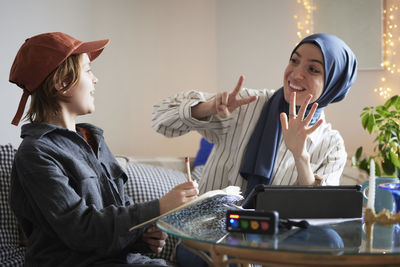 Mother wearing hijab helping son with add or adhd doing math homework