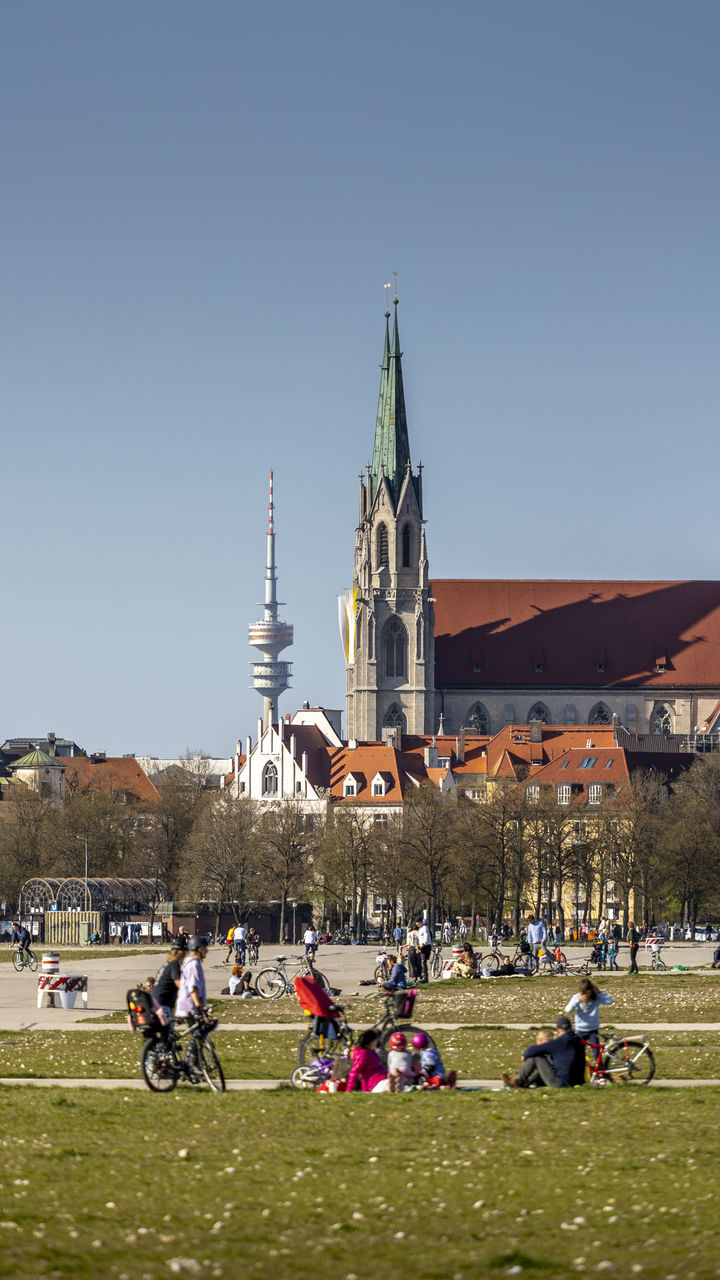 PEOPLE IN FRONT OF BUILDINGS AGAINST CLEAR SKY