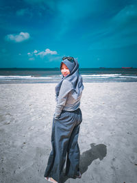 Full length of young woman standing on beach