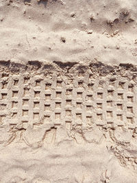 High angle view of tire tracks on sand