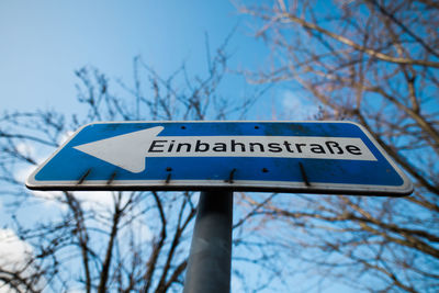 Low angle view of road sign against blue sky