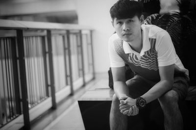 Portrait of young man sitting on bench