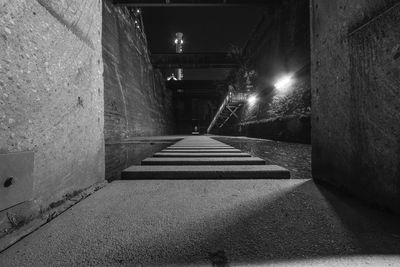 Empty road along buildings at night