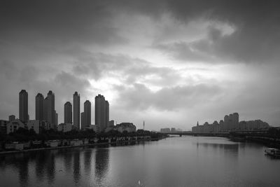 Buildings in city against cloudy sky