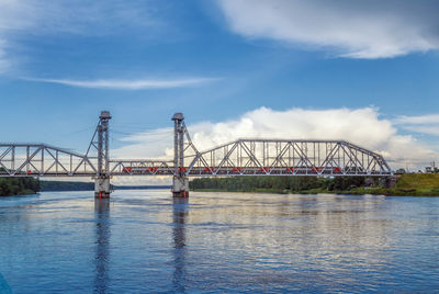 Bridge over river against cloudy sky