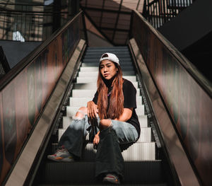Young woman sitting on staircase