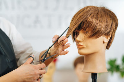 Haircutting education - hairstylist explaining haircutting techniques to students